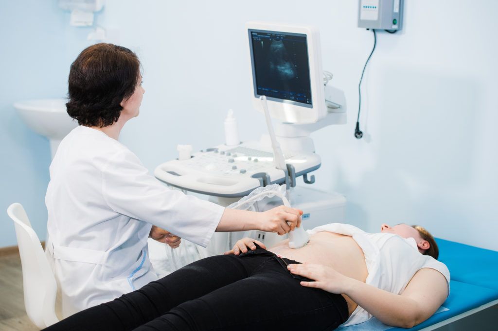 pregnant woman looking at ultrasound shots of her RDCG39F